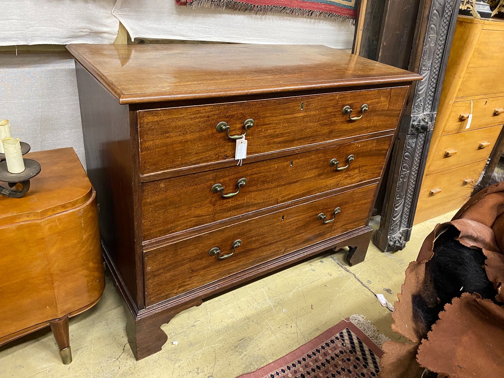 A George III mahogany chest of three long drawers, bracket supports, width 114cm, depth 55cm, height 91cm